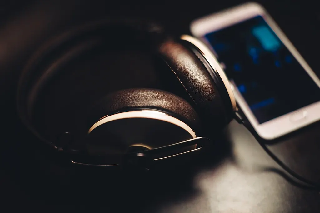 Casque audio posé à côté d'un téléphone allumé, de quoi réécouter un enregistrement de sa voix