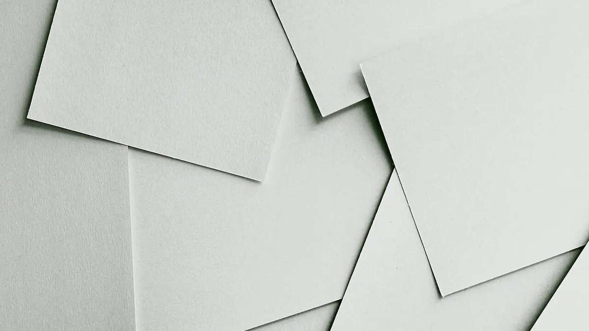 Feuilles de papier blanc vierges, éparpillées et superposées les unes sur les autres